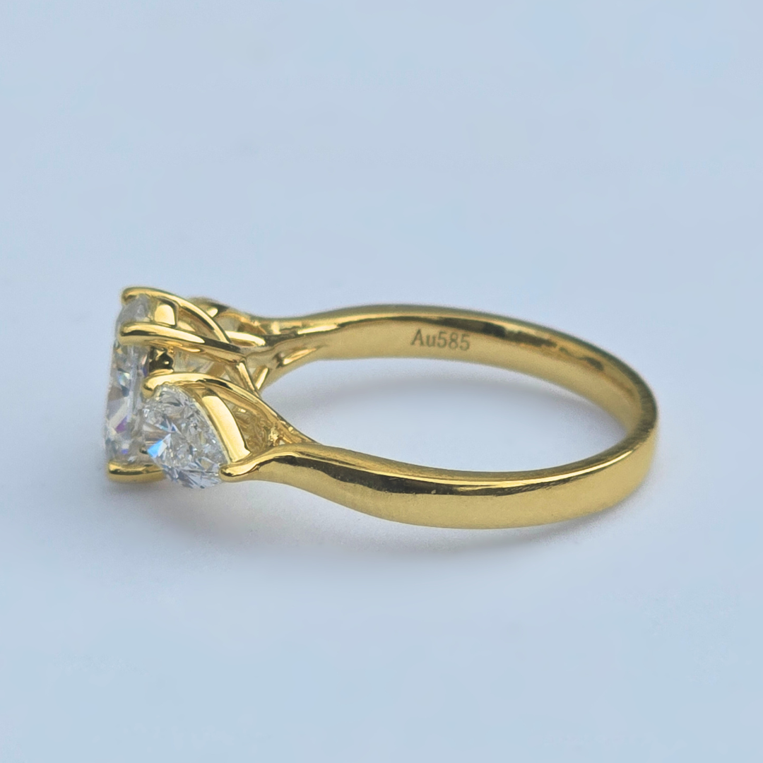 Gold ring with three lab grown diamonds oval & pear shaped side with inscription