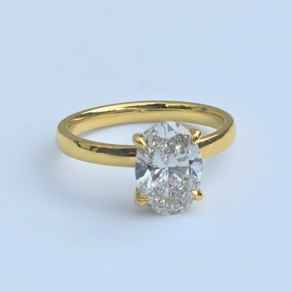 Side view of oval lab diamond solitaire ring with accent diamonds in yellow gold