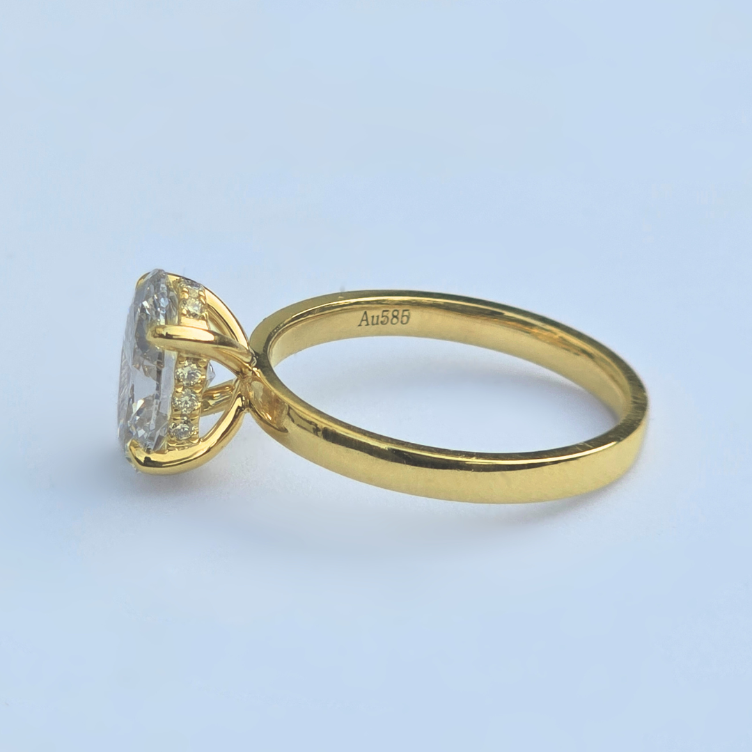 Side view of oval lab diamond solitaire ring with accent diamonds in yellow gold