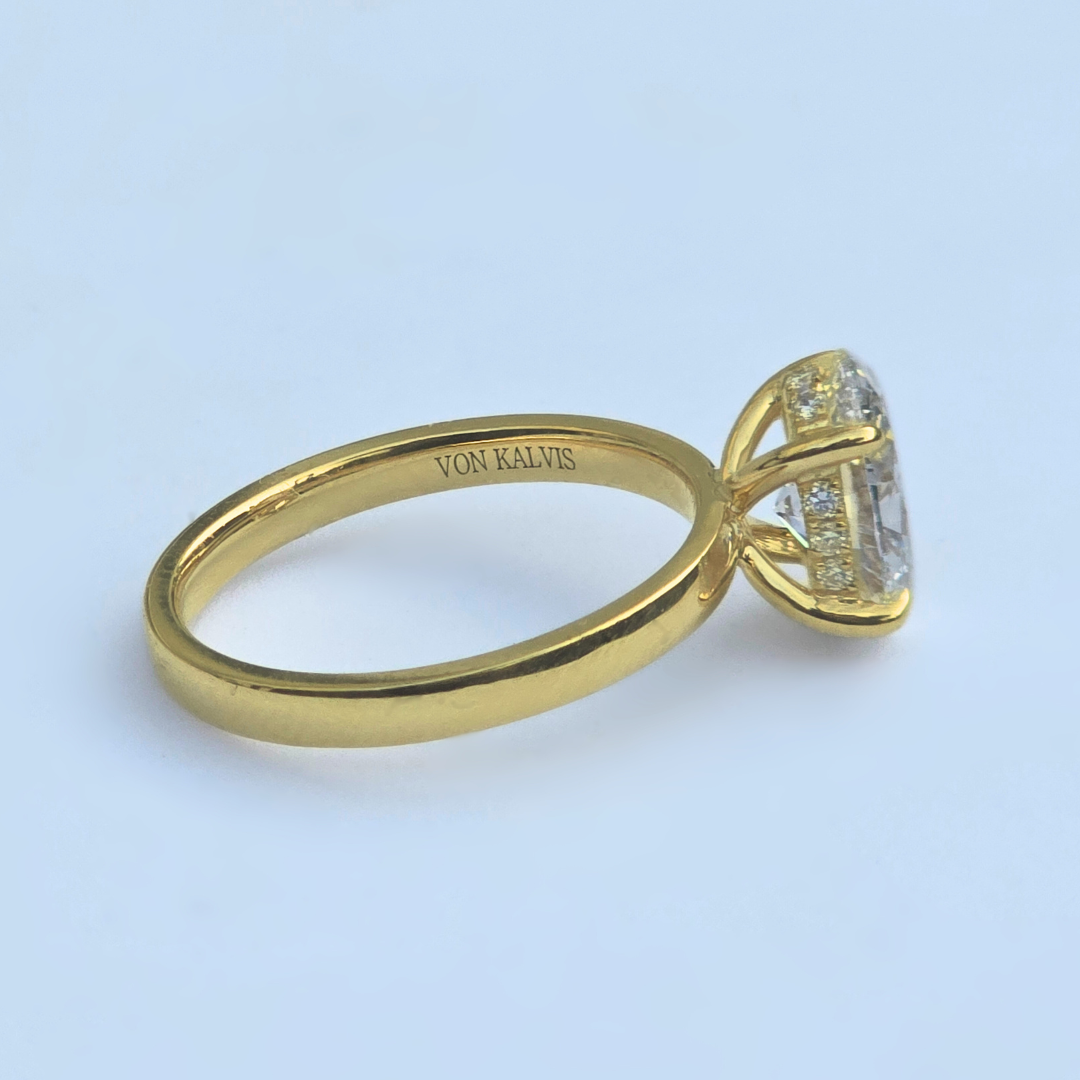 Side view of oval lab diamond solitaire ring with accent diamonds in yellow gold