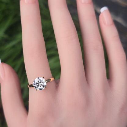 Round lab grown diamond solitaire with accents engagement ring worn on finger